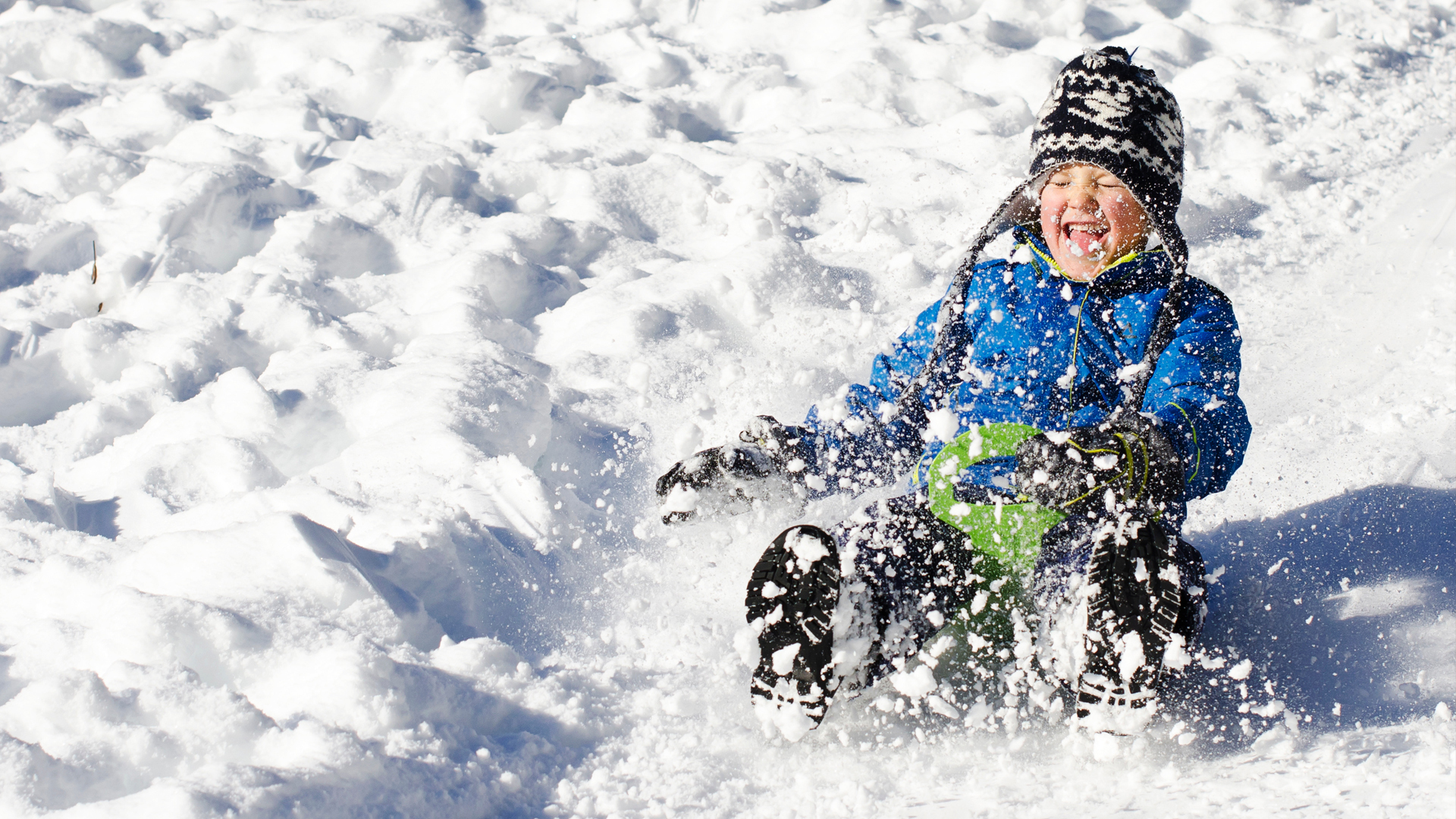 kid sledding down hill